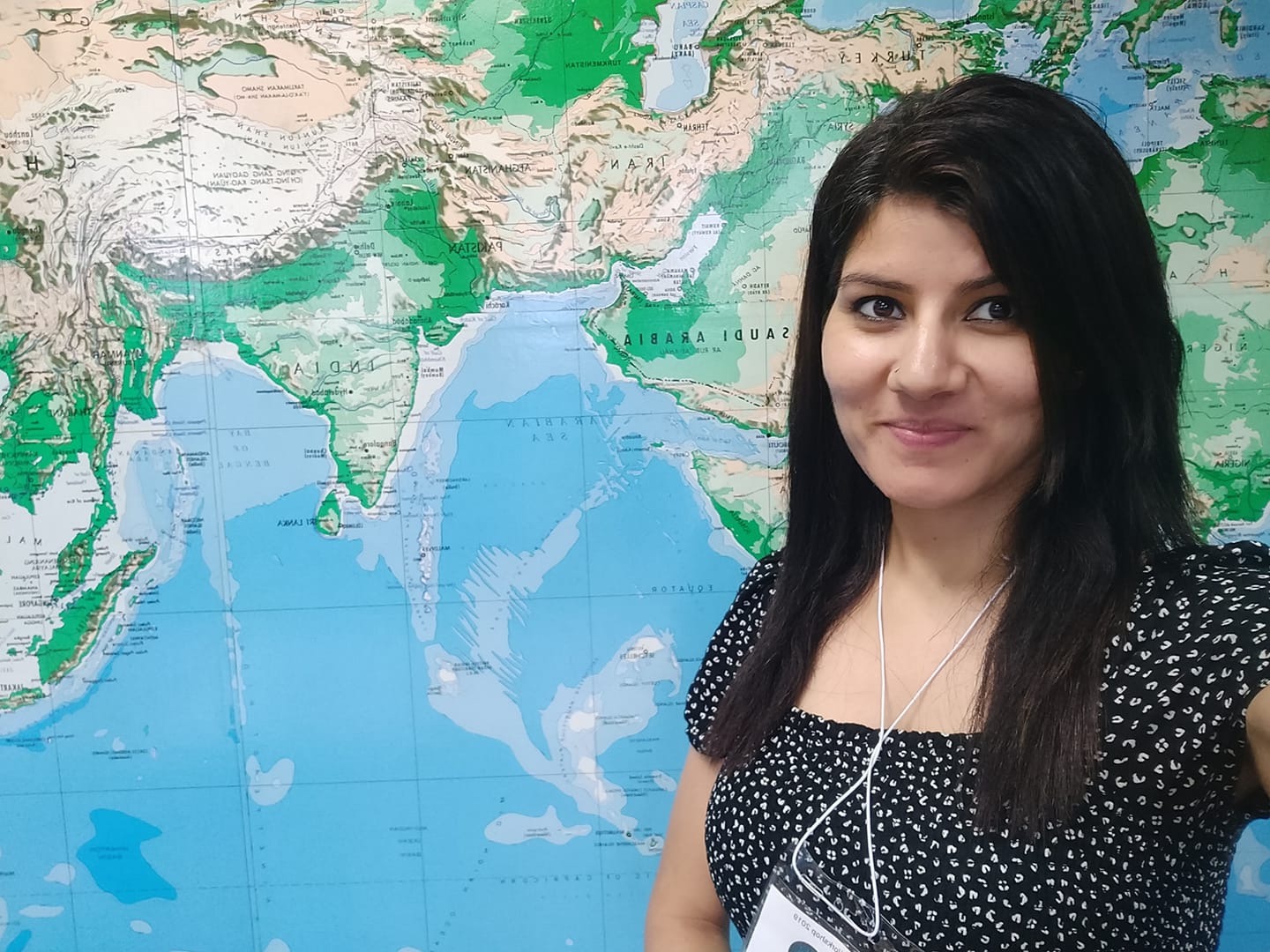 Head shot of Geeta Nain with a map background
